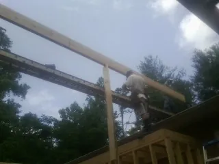 Carpenter setting a ridge beam over a new addition frame — Ice Dam Removal by Roofing Brothers in Heislerville