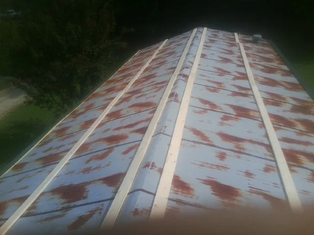 Rusted metal roof panels with new wood purlins before replacement — Storm Damage Roof Repair in Heislerville by Roofing Brothers