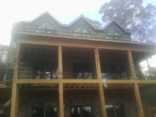 Dormers and porch framing on a large log home under construction — Roof Coating work by our crew in Heislerville